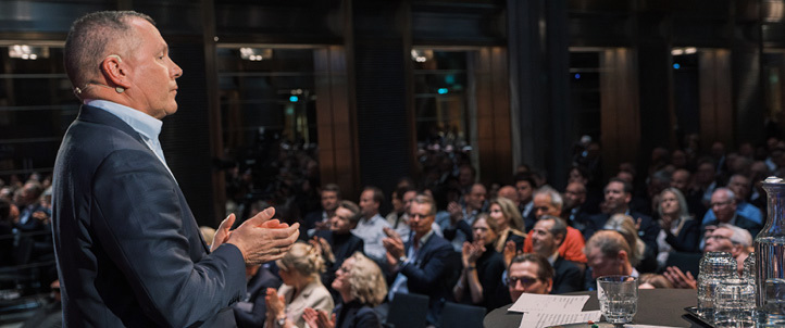 En mann står og snakker foran sittende tilhørere