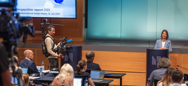 Ida Wolden Bache at a lectern in Norges Bank’s auditorium with members of the press in attendance.