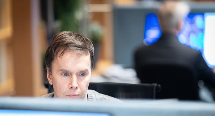 Man sitting at his desk, looking at a computer screen