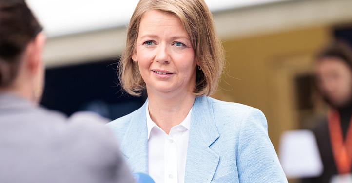 Stående kvinne som blir intervjuet av mann med mikrofon