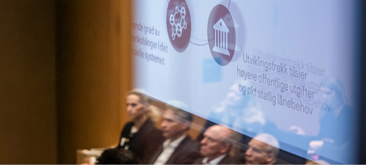 Refleksbilde av sittende tilskuere i en presentasjonsskjerm med grafikk