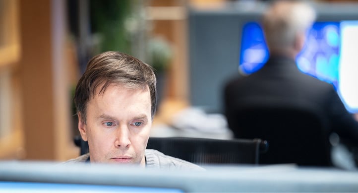 Sittende konsentrert mann som ser mot dataskjerm