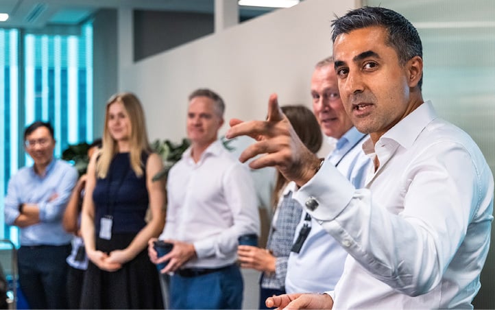 En mann i forgrunnen peker og forklarer for en liten gruppe mennesker stående bak ham