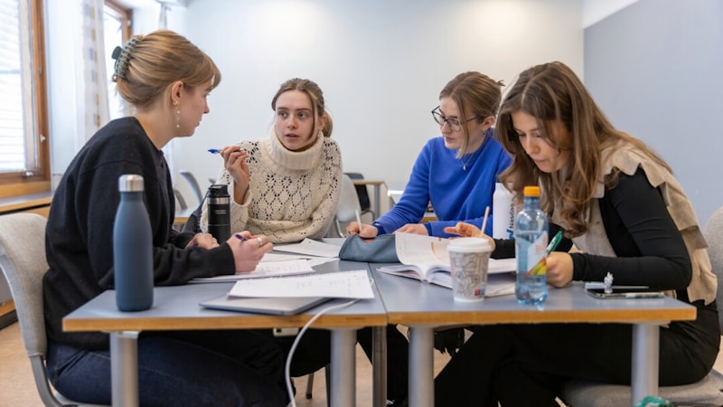 Fire studenter jobber med oppgave rundt et bord